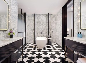 A modern bathroom with a freestanding bathtub, marble walls, and a black-and-white patterned floor. - Sofitel Changzhou Hi-tech District (Zhenjiang)