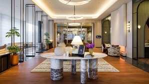 A modern hotel lobby with a marble table, seating, and a view of the city. - Sofitel Changzhou Hi-tech District (Zhenjiang)