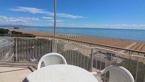 Ein Balkon mit Blick auf Strand und Meer.