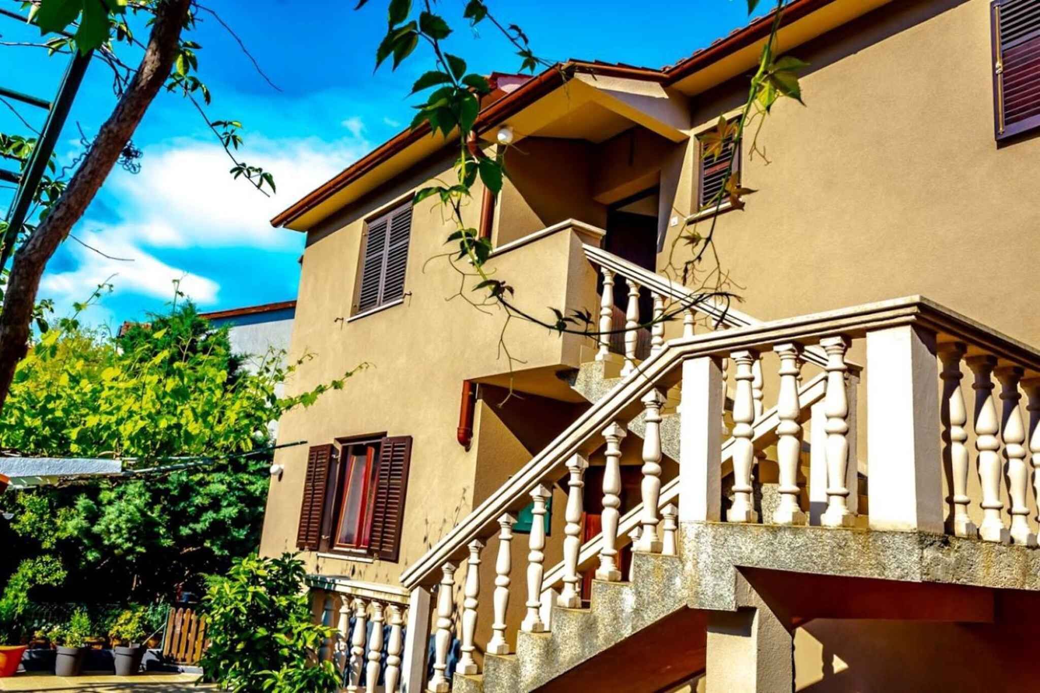 A two-story building with a stone staircase and a balcony.