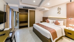 A hotel room with a bed, bedside table, TV, desk, and a wardrobe. - Hotel Star Place - Chennai (Chennai)