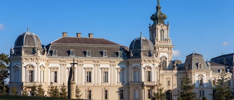 Um edifício grande e histórico com várias cúpulas e uma torre imponente.