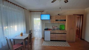 Eine kompakte Küche mit Holzausstattung, einer kleinen Arbeitsplatte und einem eingebauten Geschirrspüler.