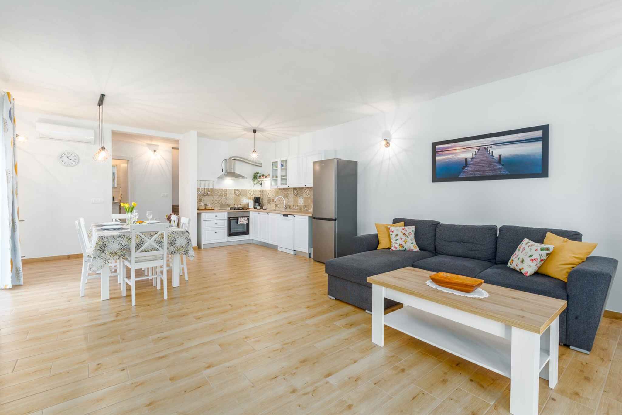 A modern apartment with a dining area, kitchen, and living room.