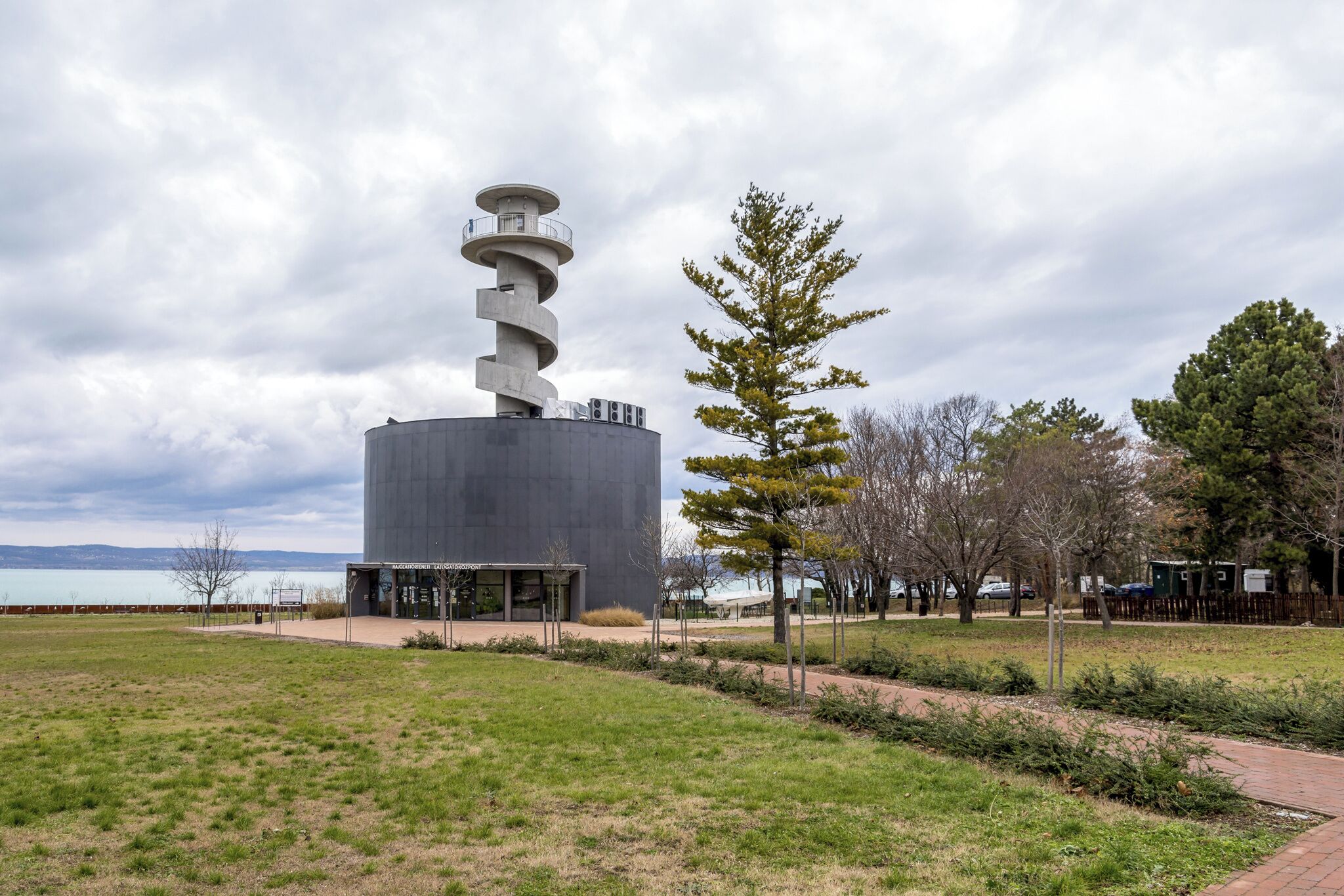 Un bâtiment moderne à la conception en spirale, doté d’une plateforme d’observation et d’un chemin d’accès menant à celle-ci.