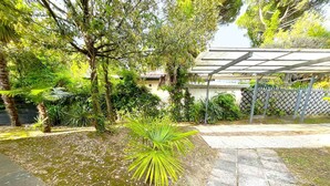Ein Garten mit Wasserspiel, Palmen und einer Pergola.