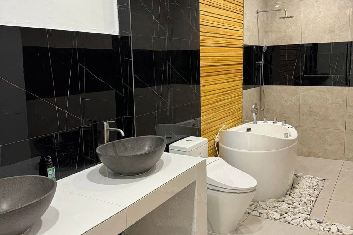 A modern bathroom with a large sink, toilet, and bathtub.