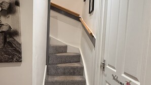 Una escalera con piso alfombrado que conduce a una plataforma.