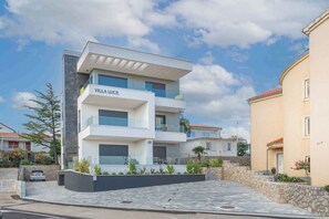 Une villa moderne, avec une plaque portant l’inscription « VILLA LUCE », une façade en pierre et une allée pavée.