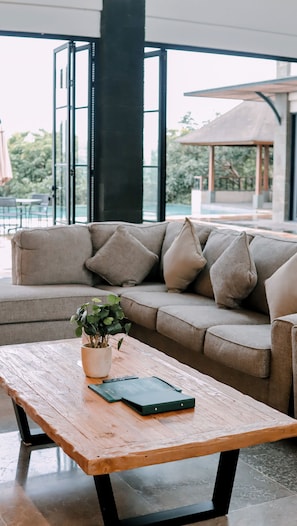 Una sala moderna con un sofá modular, una mesa de centro de madera y una planta en maceta.