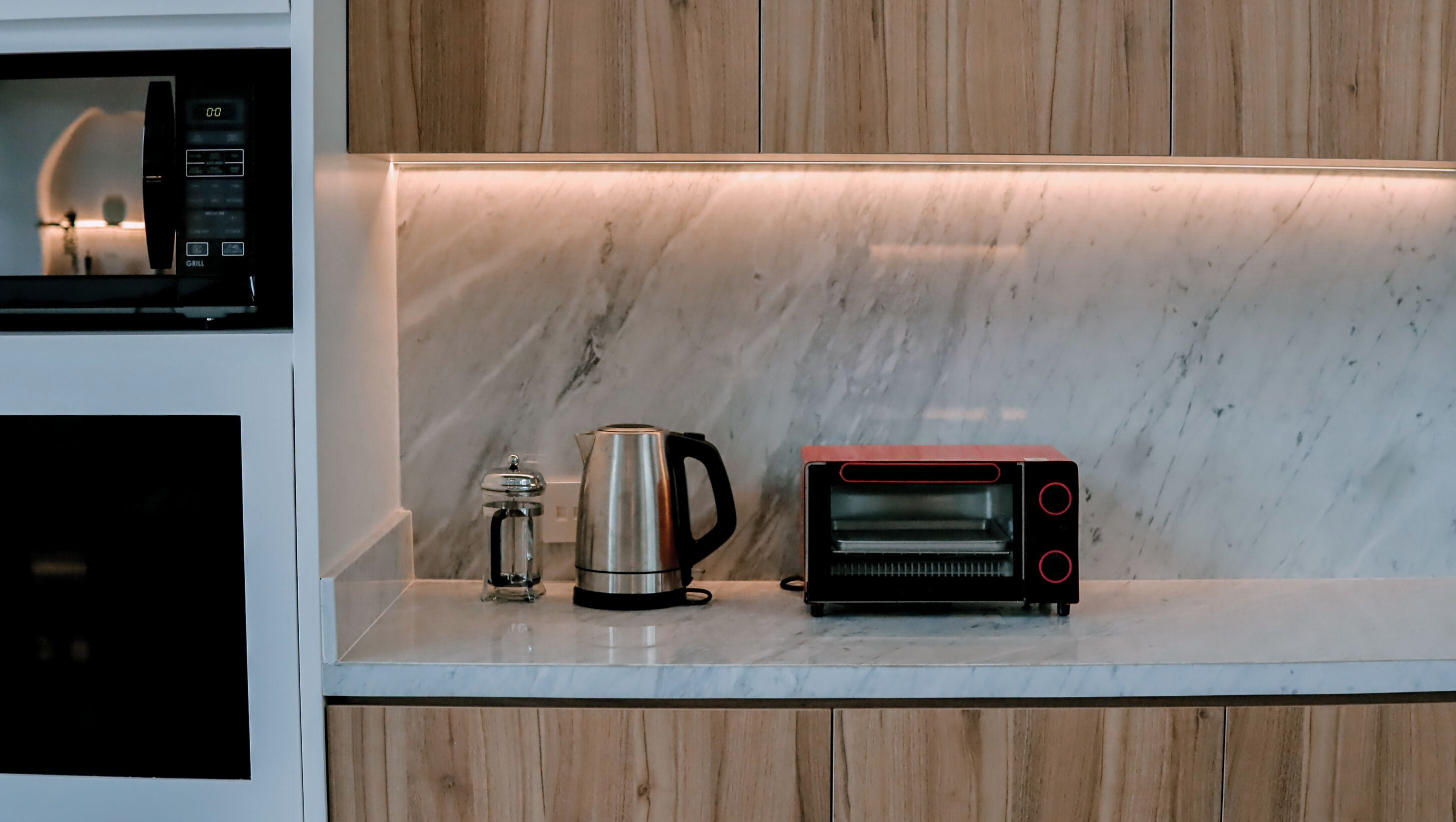 Un comptoir de cuisine avec une machine à café, une bouilloire et un four grille-pain.