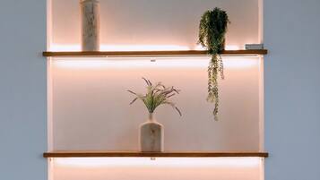 A wall-mounted shelf unit with three shelves, each containing different decorative items.