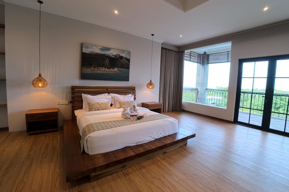 Une chambre spacieuse avec un grand lit, une tête de lit en bois et un balcon avec vue.
