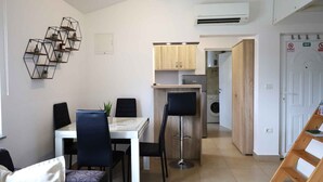 Una cocina moderna con comedor, un taburete de bar y lavandería.
