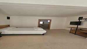 Una habitación con una cama, un televisor y una estantería de madera.
