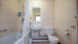 Une salle de bain équipée d’une baignoire, d’un lavabo, de toilettes et d’une douche.