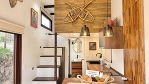 Een moderne keuken met een houten accentmuur, een decoratieve wanddecoratie en een welkomstbord.