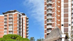 A high-rise building with multiple balconies and a clear sky. - Holiday flat with air conditioning and balcony with sea view (Lignano Sabbiadoro)
