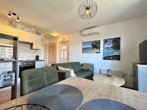A modern living space with a kitchen, a dining area, and a seating area with a sofa and a table. - Holiday apartment comfortably furnished with air conditioning (Krk)
