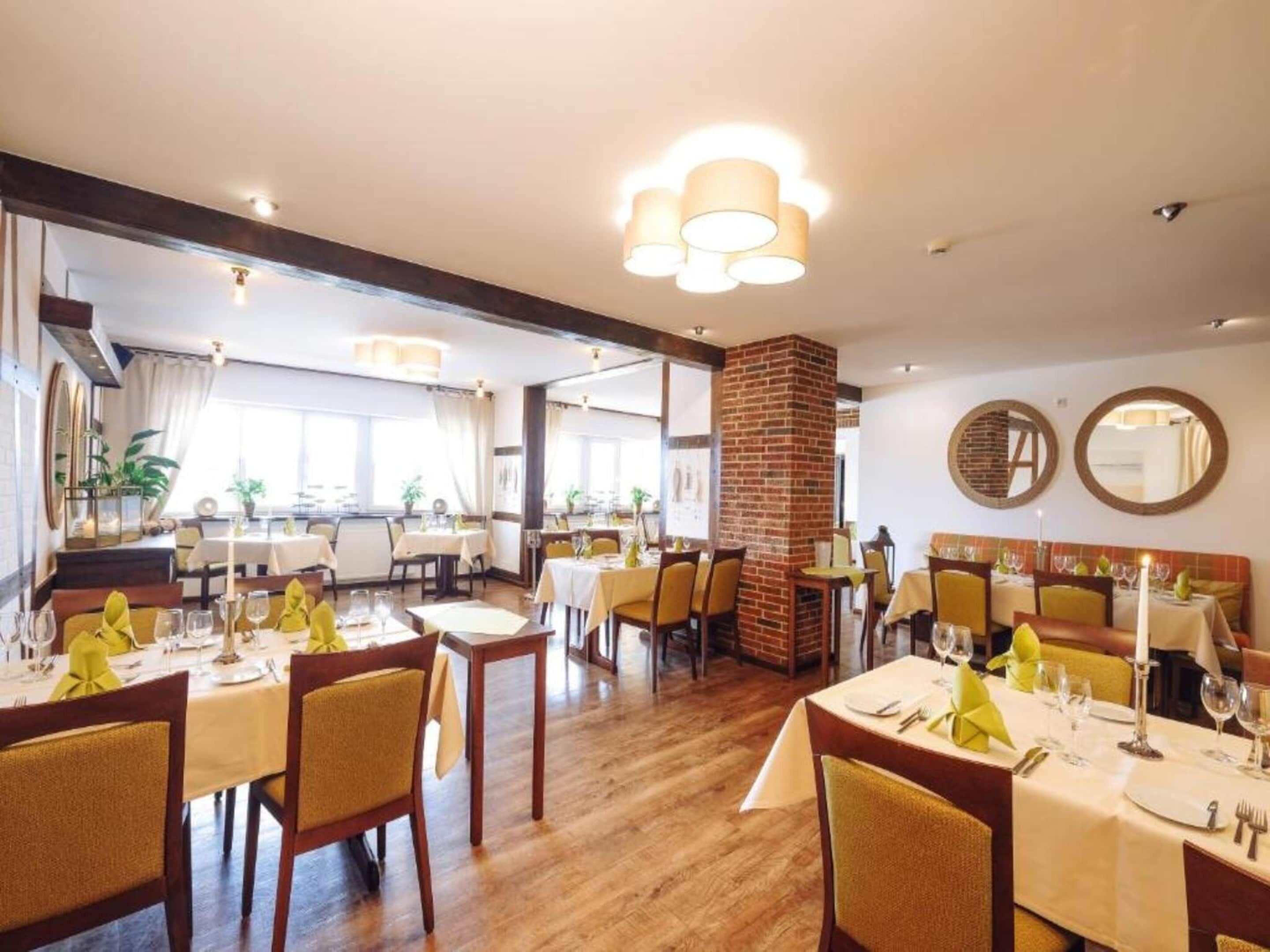 Un restaurante con varias mesas, sillas y una columna de ladrillo.
