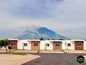 A row of modern single-story houses with a mountain in the background.