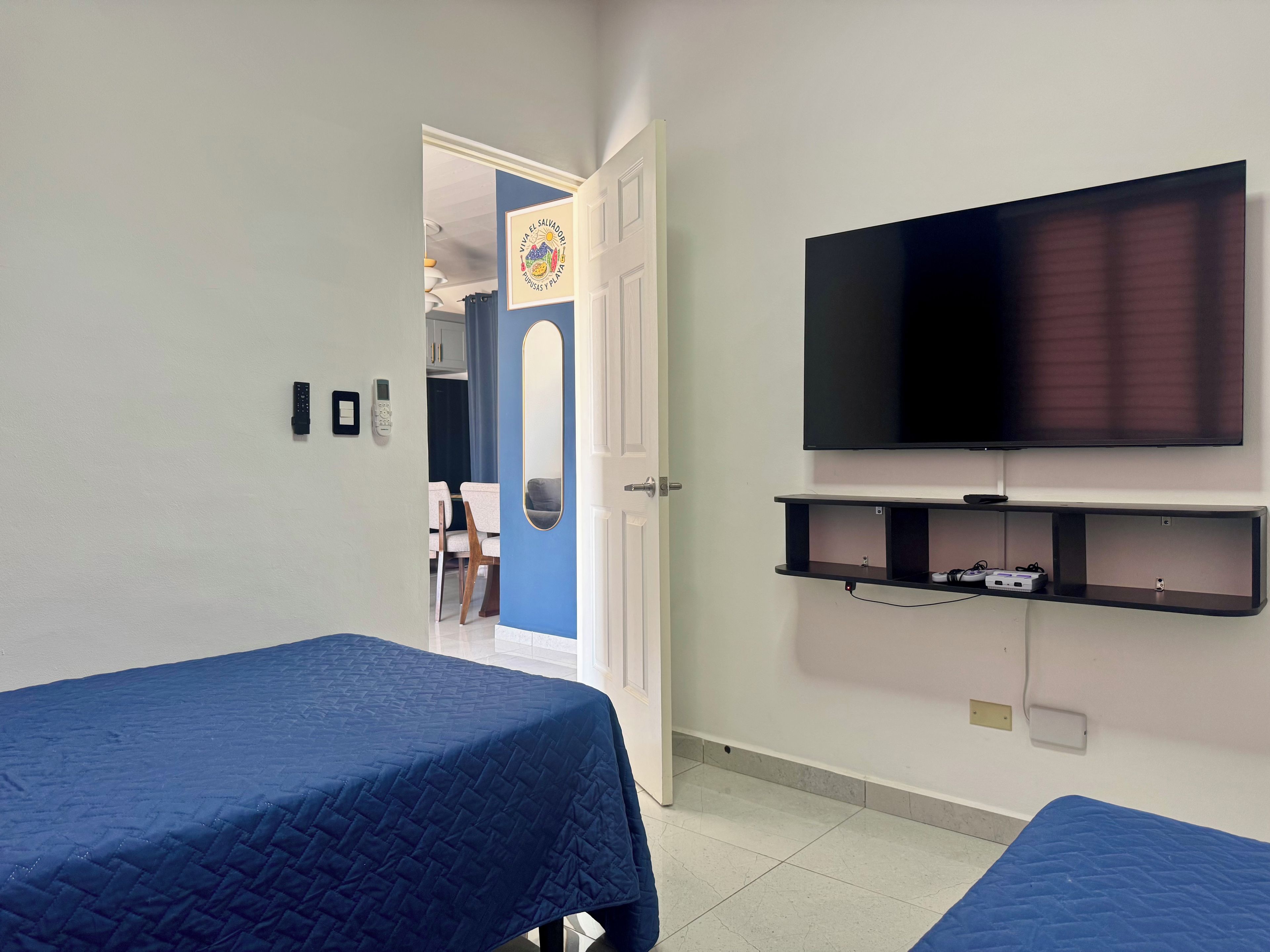 Une chambre avec deux lits, une télévision et un bureau équipé d’un ordinateur.