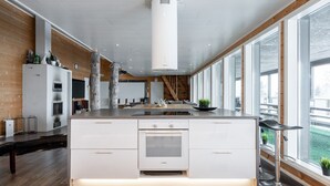 A modern kitchen with a central island, built-in appliances, and large windows offering views.