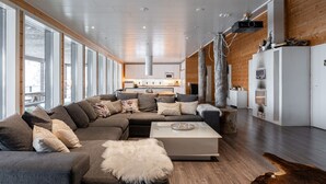 A modern living room with a large sectional sofa, a coffee table, and a fireplace.