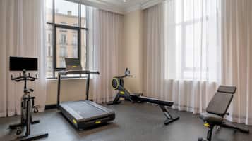 A gym with a treadmill, exercise bike, and rowing machine.