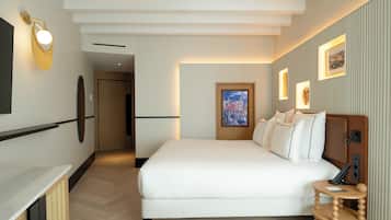 Habitación de hotel con una cama grande, una mesita de noche, una lámpara de pared y un cuadro enmarcado en la pared.