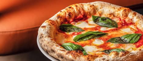 A pizza on a white plate on a table.