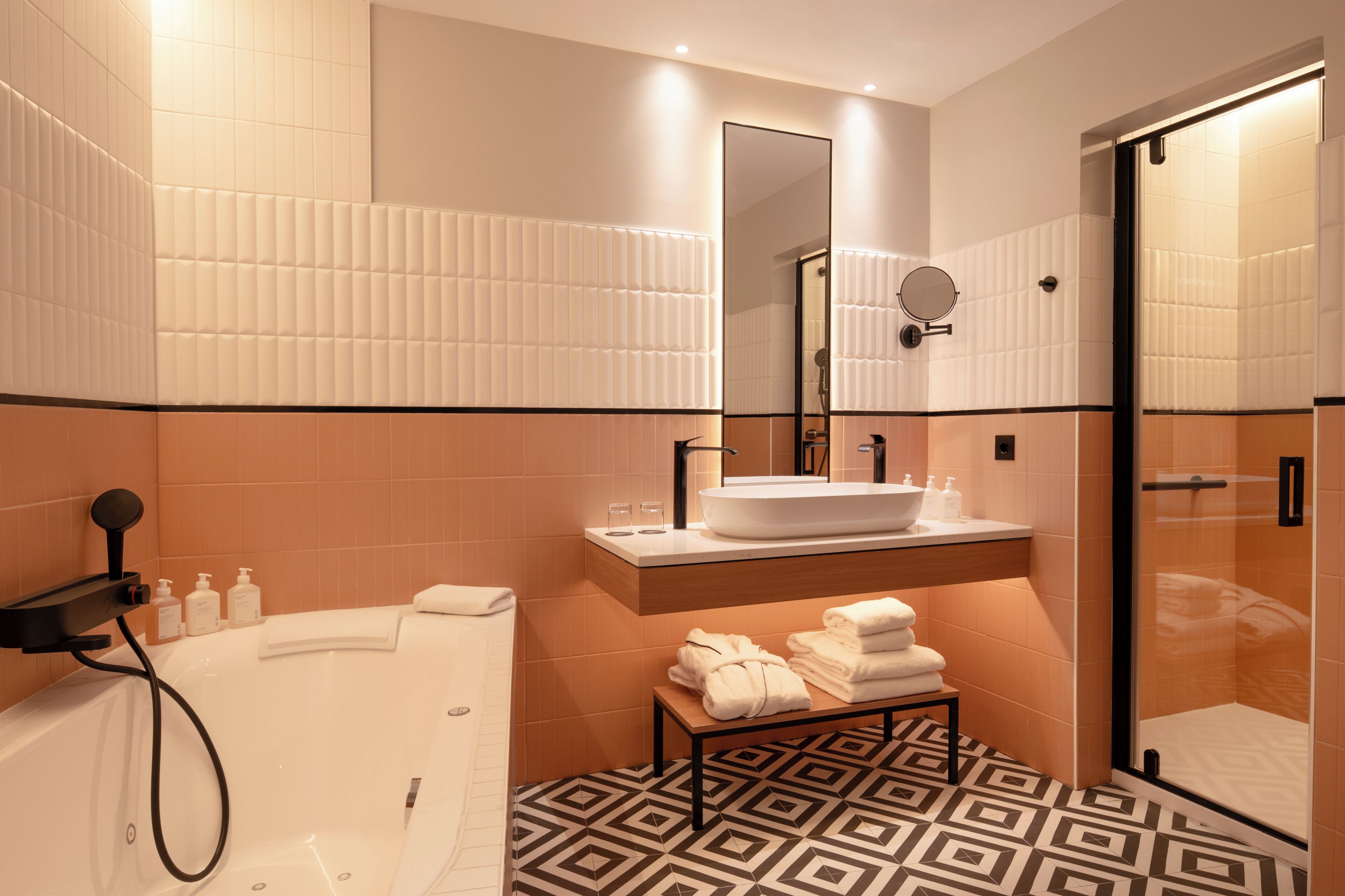 A modern bathroom with a bathtub, a sink, a mirror, and a shower.