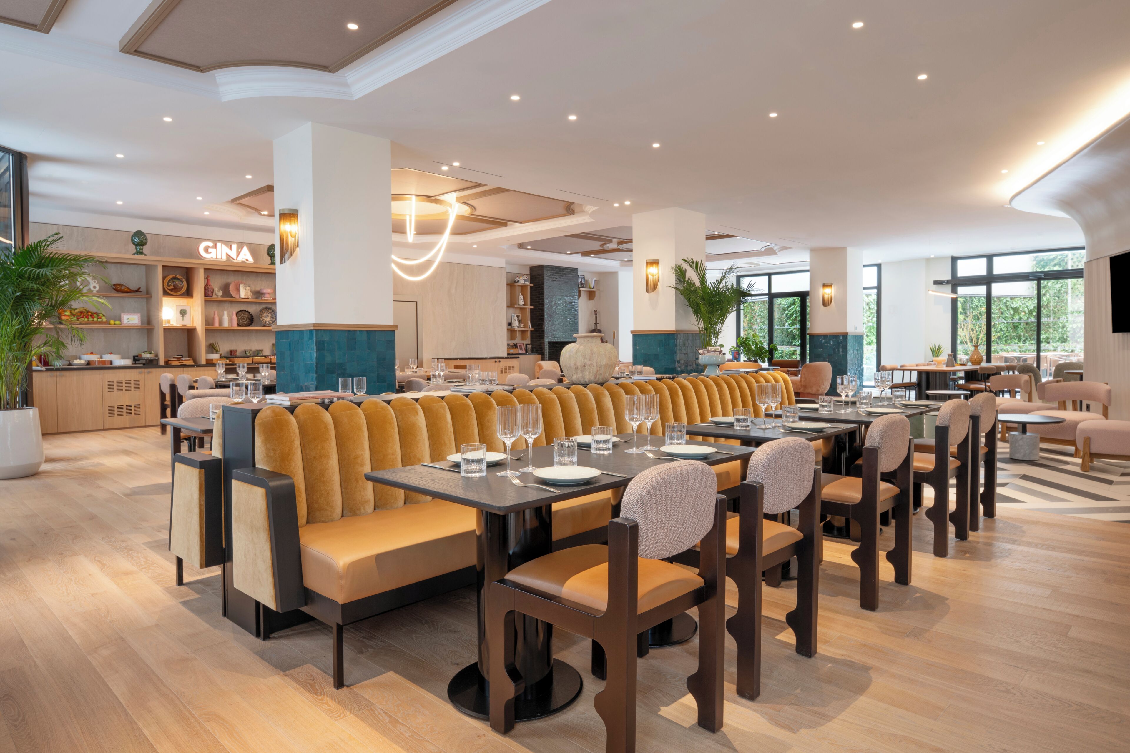 A modern restaurant with a long dining area, booths, and a bar.