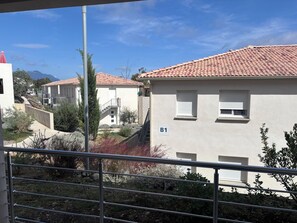 A residential building with a tiled roof, a balcony, and a sign indicating room B1. - Apartment T3 Marine de Bravone feet in the water (Linguizzetta)