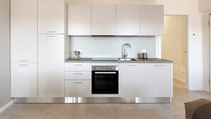 A modern kitchen with stainless steel appliances, white cabinetry, and a built-in oven. - Giulio's Apartment First Floor (San Zeno di Montagna)
