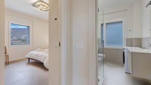 A bedroom with a large window, a bed, and a view of a landscape. - Giulio's Apartment First Floor (San Zeno di Montagna)