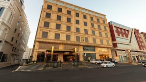 Un hotel a più piani dal design architettonico classico, caratterizzato da un ingresso imponente con tenda e un cartello ben visibile per Dr. S' Lounge.