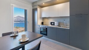 Una cocina moderna con vistas a la montaña, una mesa de comedor con tazas y un microondas.