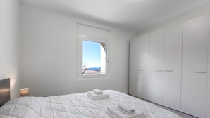 Un dormitorio con cama, ventana y armario.