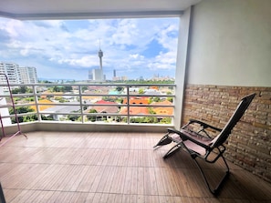 A balcony with a view of a cityscape, including a tower and various buildings. - Sea-view Studio With Large Balcony - View Talay 5D (Pattaya)