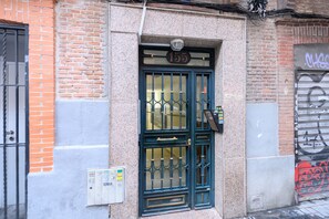 A building facade with a numbered door, a utility box, and a graffiti-covered shutter. - M (JJU15503) Duplex with terrace in Goya (Madrid)
