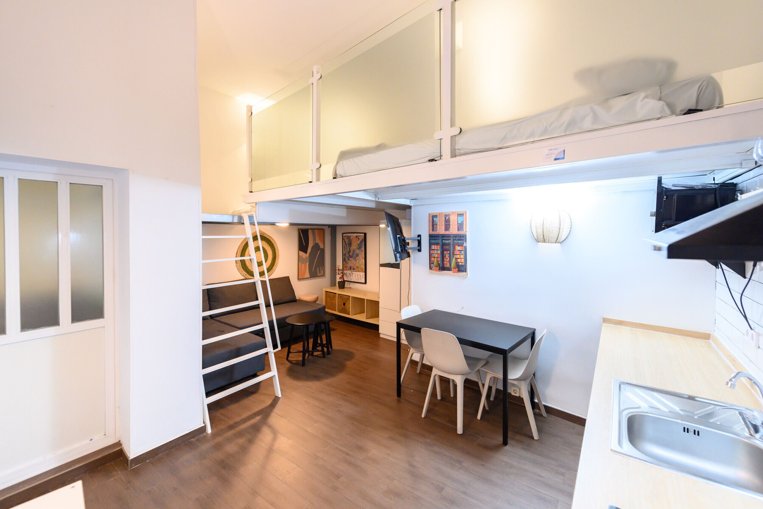 Ein kompaktes Apartment mit Küchenzeile, Essbereich und Schlafgalerie.