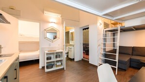 A compact living space with a kitchenette, a bed, a built-in wardrobe, a ladder, a sofa, and a dining area. - M (JJU15503) Duplex with terrace in Goya (Madrid)