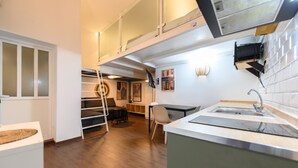 A modern kitchen with a built-in dishwasher, a sink, and a dining area with a table and chairs. - M (JJU15503) Duplex with terrace in Goya (Madrid)