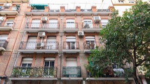 A multi-story brick building with balconies, air conditioning units, and a tree in the foreground. - M (JJU15503) Duplex with terrace in Goya (Madrid)