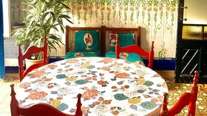 A dining area with a round table, red chairs, a hanging light fixture, and two framed posters on the wall. - Beachfront house. 30 minutes from Barcelona (Premià de Mar)