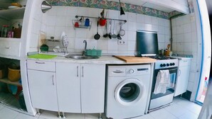 A compact kitchen with a washing machine, a stove, and a sink. - Beachfront house. 30 minutes from Barcelona (Premià de Mar)