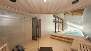 A modern bathroom with a glass shower enclosure, a wooden vanity, and a hot tub. - Rural house ORUE BASERRIA in URDAIBAI-with jacuzzi and sauna (Ajuria)