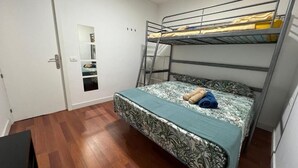 A room with a bunk bed, a small desk, and a door with a mirror. - B&B paraiso tenerife  (Los Abrigos)