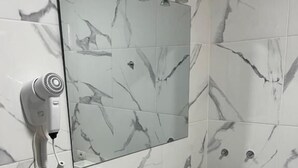 A bathroom with a white marble sink, a mirror, a hairdryer, and a blue soap dispenser. - B&B paraiso tenerife  (Los Abrigos)